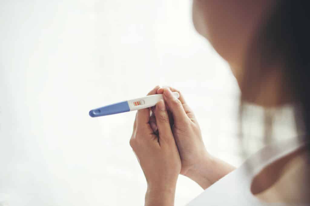 mulher segurando um teste de gravidez.